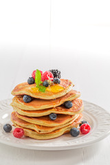 Homemade american pancakes with maple syrup and berries
