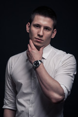 one young man, hand touching face,black background