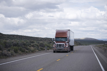 Fototapeta na wymiar Brown modern semi truck with trailer driving long Nevada highway
