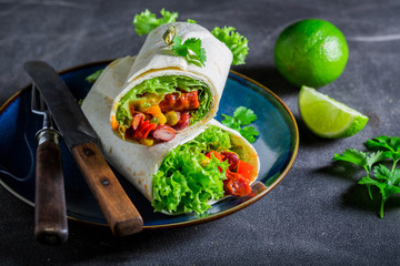 Enjoy your burrito with vegetables, spicy salsa and lime