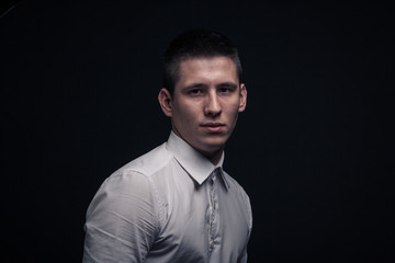 Fototapeta premium jeden młody mężczyzna, głowa w bok, głowa w głowę, czarne tło