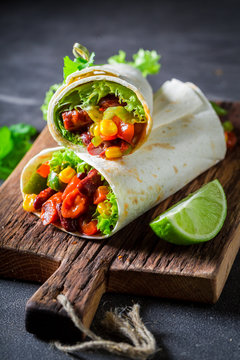 Enjoy your burrito with red salsa, lettuce and vegetables
