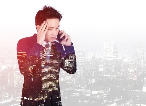 double exposure of worried businessman talking on smartphone with city background