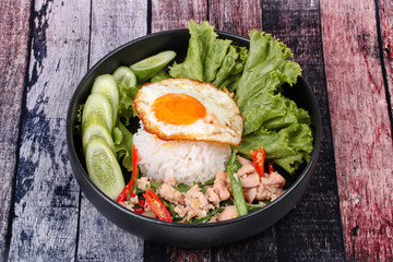 Jasmine rice topped stir - fried spicy basil with meat.