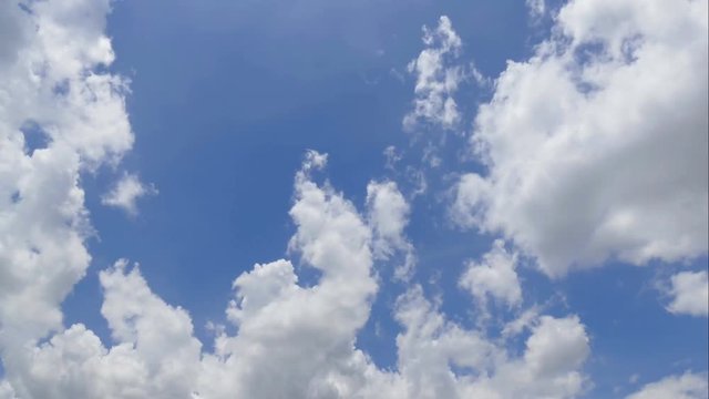 Time lapse clip of white fluffy clouds over blue sky 