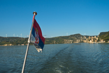Cruiser ship sales on Danube river at sunny summer day with Golubac fortress in background, Serbia