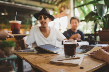 Group of young people sitting at a cafe, talking and enjoying,Friends enjoying in conversation and drinking coffee.