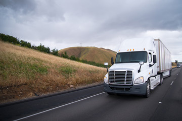 Fototapeta na wymiar Semi trucks convoy moves interstate highway in California