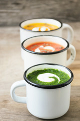 Homemade vegetarian soup made from fresh spinach  pumpkin  tomatoes poured into a white mug