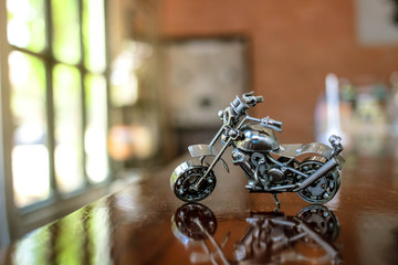 Steel chopper motorbike model with blur indoor background.