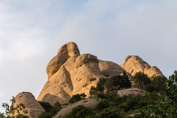Fototapeta na wymiar Amazing geological formations, strange-looking cliffs on sunset near Monastery of Montserrat, Spain