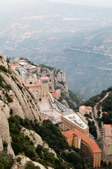 Fototapeta premium Above view of the Monastery of Montserrat, Spain, from the top of the mountain through the canyon on sunset.