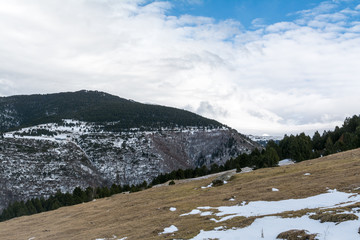 Fototapeta premium Winter Pyrenees landscape: snow-covered meadow and icy mountain peaks on background, Pyrenees, Spain