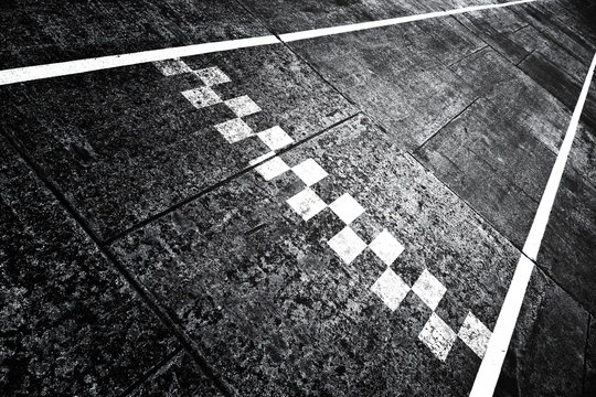 Grunge textured finish and start pattern line on the asphalt race road ground.