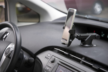 Obraz na płótnie Canvas Cellphone attached by holder to the car dashboard
