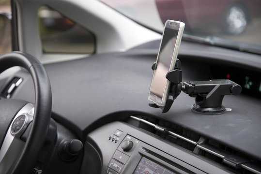 Cellphone attached by holder to the car dashboard