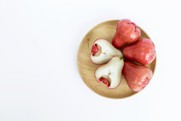 Fresh red rose apple on round wooden tray on white background