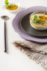 Yogurt with trapicheskim fruit, passionfruit and winter cherry in a glass vase on stone background