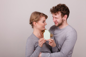 Cheerful young couple with house model.