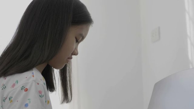 4K : Slow motion of Asian girl playing piano, Tilt down shot