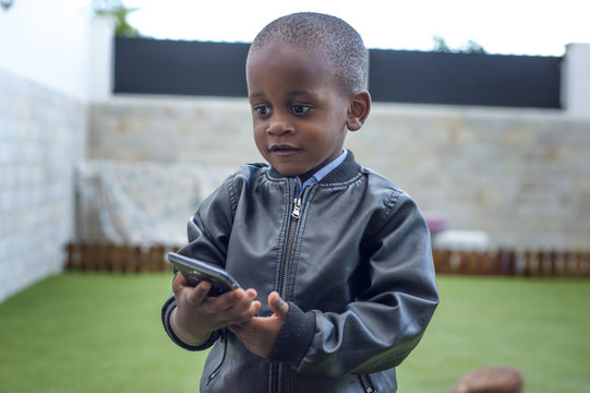 Black Child With Phone In Hand