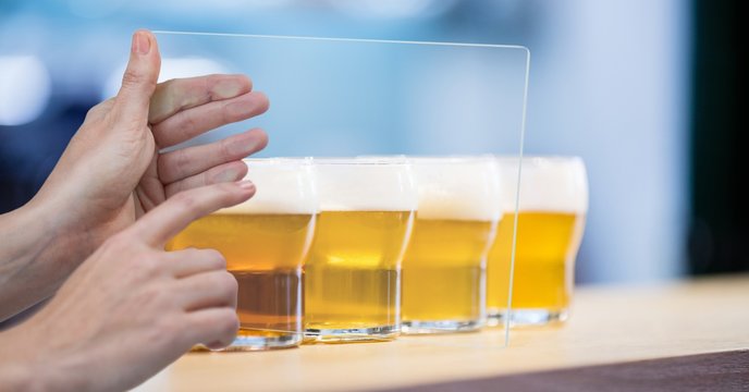 Cropped hands taking picture of beer glasses 
