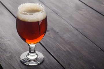 Red ale on dark wood