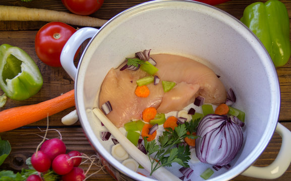 Preparation of chicken soup. Chicken and mixed fresh vegetables in the pot