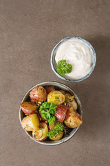 Body multicolored potato baked with herbs and garlic on olive oil, Dark background. Food for a vegan and a vegetarian.