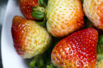 Immature red strawberries with green tails