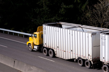 Yellow day cab big rig semi-truck on the road