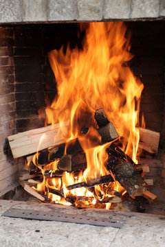 Flame of burning logs in the fireplace