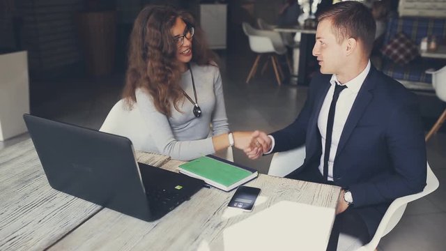 Business partners, woman and man shaking hands