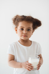 cute little kid girl holding glass of milk isolated on white