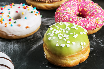 Glazed donuts with different fillings on a black table