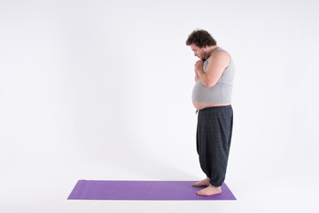 Fototapeta na wymiar Funny fat man and yoga. Sport, diet and a healthy lifestyle. 