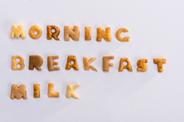 Close-up view of words morning, breakfast, milk from alphabet corn flakes isolated on grey