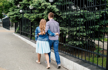 Obraz premium Loving couple embracing and walking through the city, back view