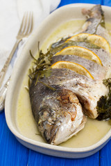 baked fish with lemon on dish