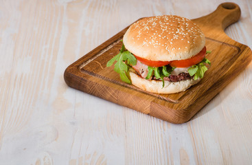 Tasty burger on a wooden background copyspace
