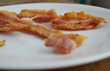 Macro detail of unhealthy crispy bacon strips as a symbol of typical American breakfast food 