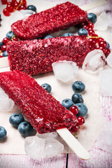 Fruit ice cream with raspberries and blueberries on a stick on the table