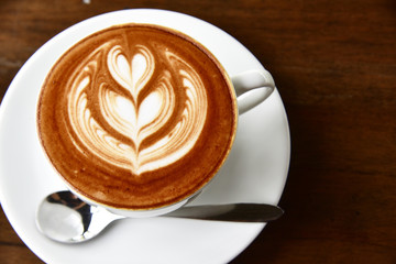 closeup cup of coffee latte art and mocha on old brown wooden background square frame image.