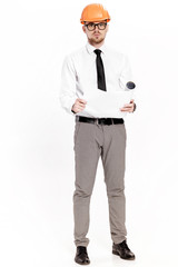 Young construction engineer in orange helmet studying layout plan on white background