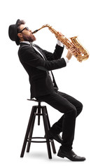 Jazz musician seated on a chair playing a saxophone