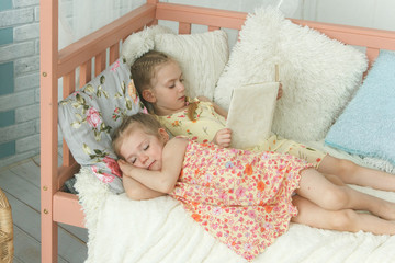 Older sister reading a book to her younger sister