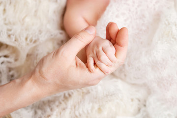 Newborn children's hand in mother hand. Mom and her Child. Happy Family concept. Beautiful conceptual image of Maternity