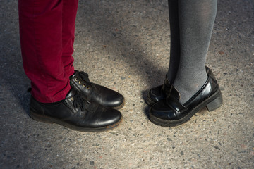 Fototapeta na wymiar Love story told by boots. Human feet close up. Man and woman in elegand shoes. Girl in black shoes. Guy in black shoes and leather. Lady and gentleman couple in summer. Legs close up.