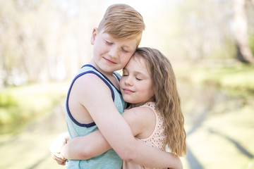 Fototapeta premium Portrait of a little girl on a yellow background. with his brother