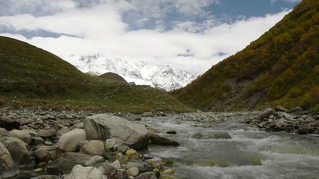 Amazing touristic place near river in mountain valley at the foot of Mt. Shkhara 5,193 m (17,040 ft). Upper Svaneti, Georgia, Europe. Caucasus mountains. HD video clip (High Definition).